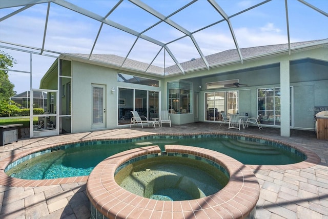 back of house featuring a lanai, ceiling fan, a swimming pool with hot tub, and a patio area