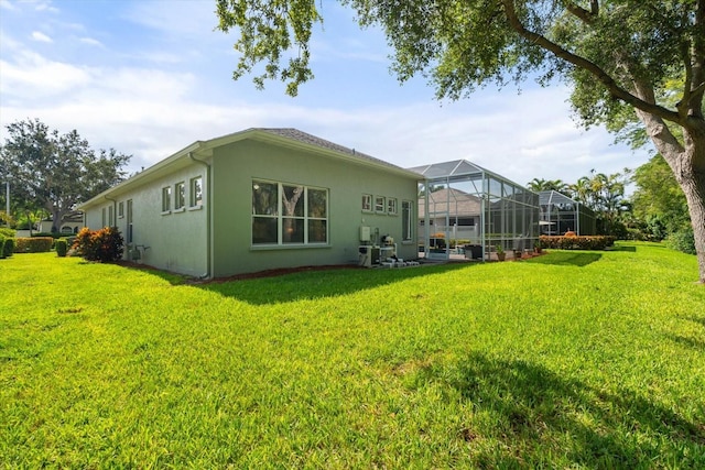 rear view of house featuring a lanai and a lawn