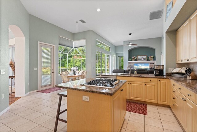 1206 86th Ct NW, Bradenton, FL 34209 - kitchen with stainless steel gas stovetop, light tile patterned floors, light brown cabinetry, dark stone countertops, and recessed lighting