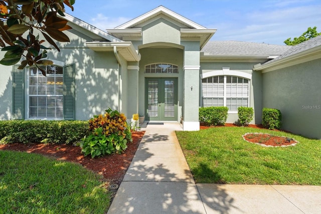 1206 86th Ct NW, Bradenton, FL 34209 - entrance to property featuring french doors, stucco siding, a lawn, and roof with shingles