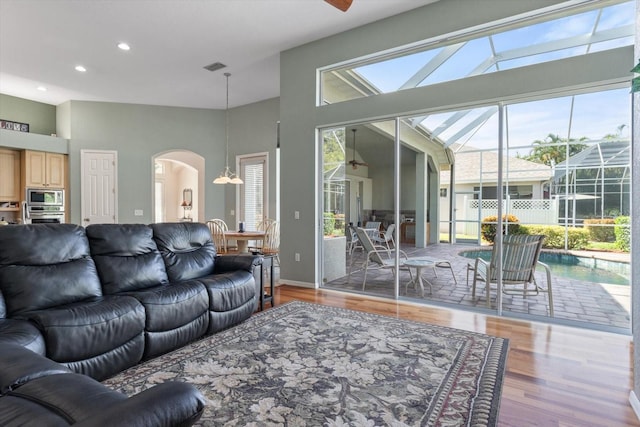 living room with high vaulted ceiling and light hardwood / wood-style flooring