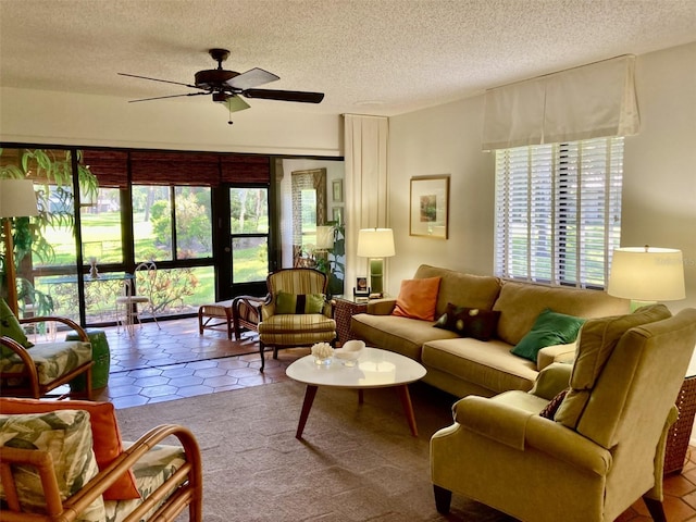 living room with ceiling fan, light tile patterned flooring, a healthy amount of sunlight, and a textured ceiling