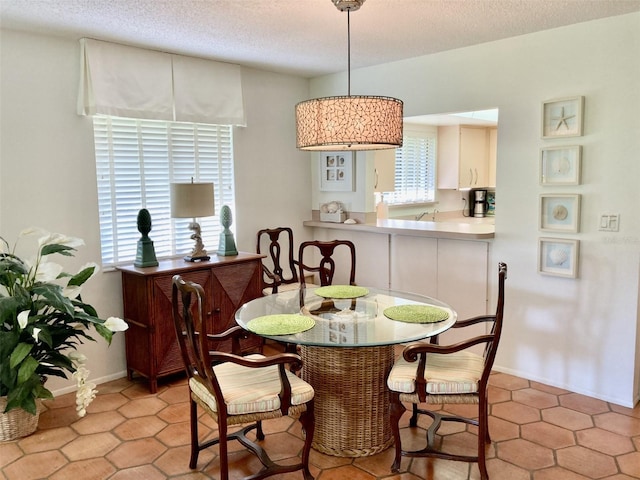 dining space with light tile patterned floors and a textured ceiling