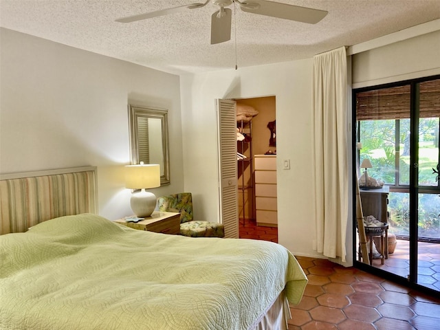 bedroom featuring access to exterior, a textured ceiling, ceiling fan, a spacious closet, and a closet