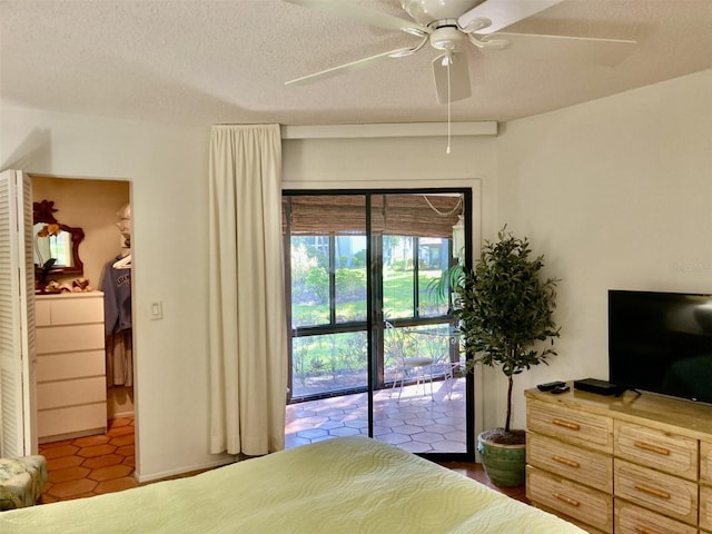 tiled bedroom featuring access to exterior, a textured ceiling, and ceiling fan