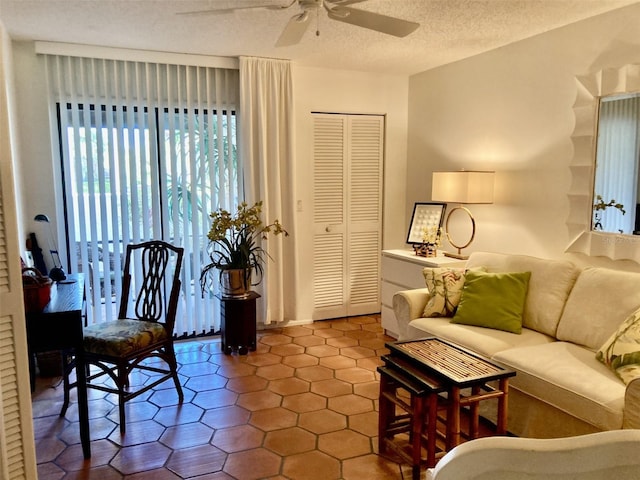 living room with ceiling fan and a textured ceiling