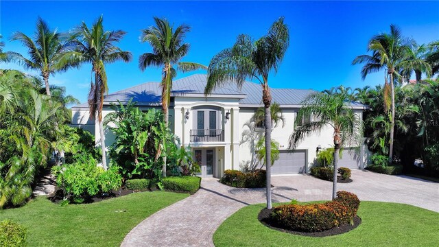 view of front facade featuring a garage, a front lawn, and a balcony