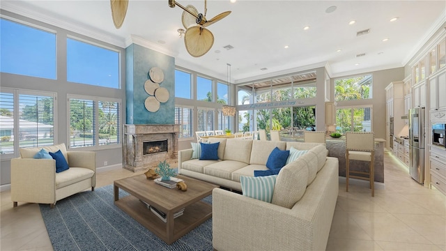 living room featuring crown molding, ceiling fan, light tile patterned flooring, and a fireplace