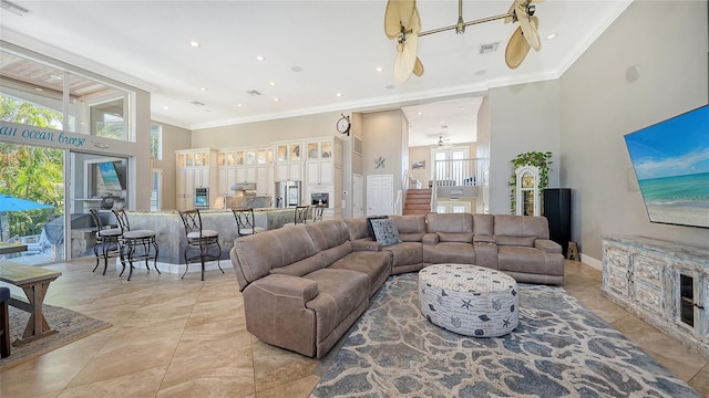 living room featuring crown molding, ceiling fan, and a high ceiling