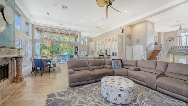 living room with a high end fireplace, crown molding, a high ceiling, and ceiling fan