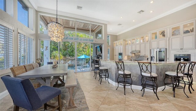 kitchen featuring pendant lighting, crown molding, white cabinetry, a chandelier, and stainless steel refrigerator with ice dispenser