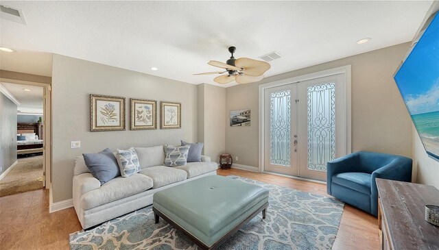 living room with ceiling fan, light hardwood / wood-style floors, and french doors