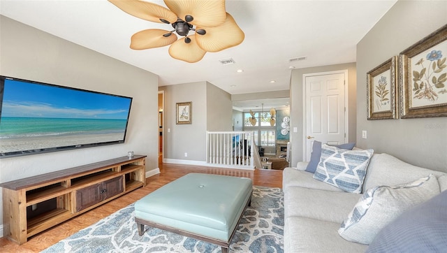 living room with ceiling fan with notable chandelier and wood-type flooring