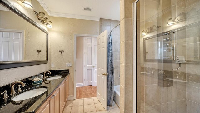 bathroom featuring crown molding, vanity, tile patterned floors, and a shower with door