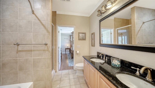 bathroom with hardwood / wood-style floors, toilet, a tile shower, and vanity