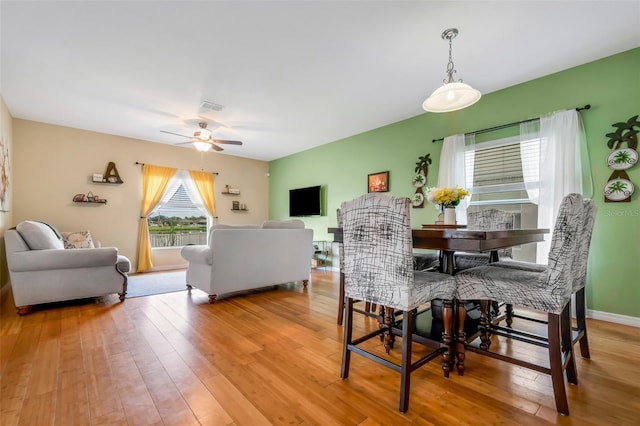 dining room with light wood-type flooring, ceiling fan, visible vents, and baseboards