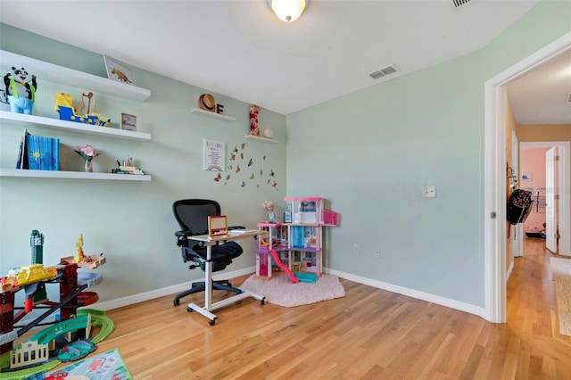 playroom with light wood-style flooring, visible vents, and baseboards