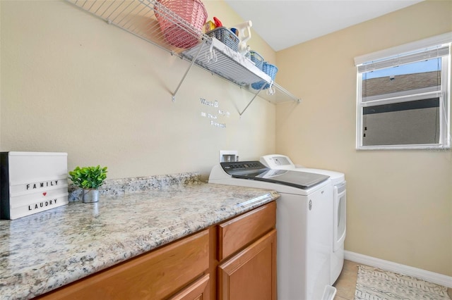 laundry room with light tile patterned floors, separate washer and dryer, and baseboards