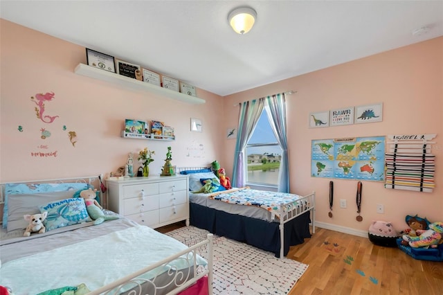 bedroom with light wood-style flooring and baseboards