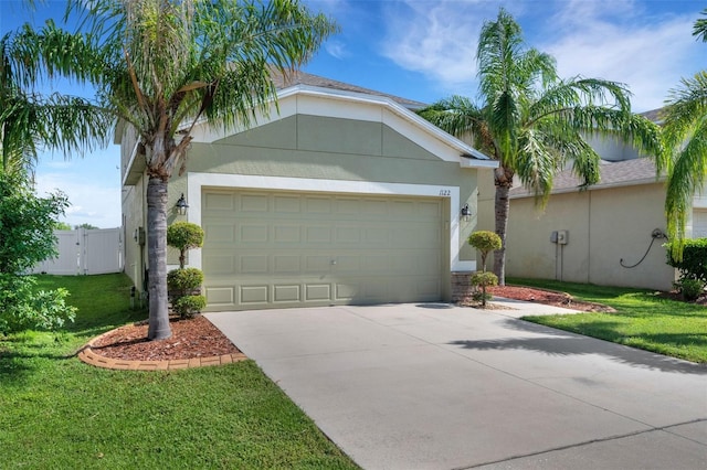 view of front of home featuring a front yard, concrete driveway, and stucco siding