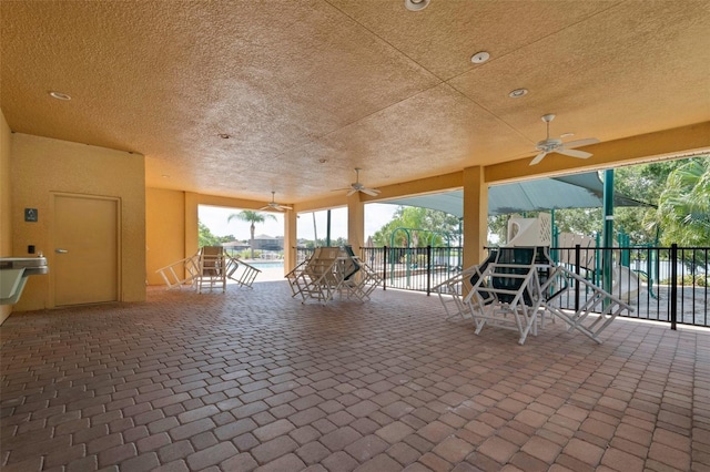 view of patio featuring ceiling fan, fence, and playground community