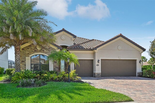 mediterranean / spanish home with a garage and a front yard