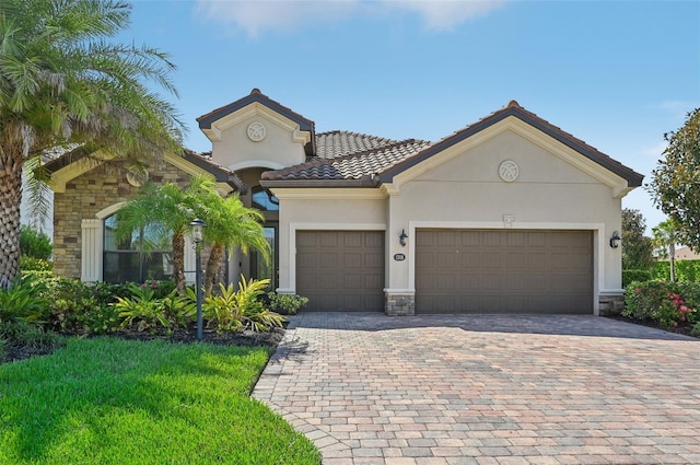 mediterranean / spanish home featuring a garage and a front yard