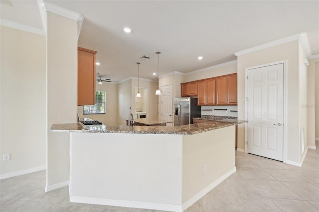 kitchen with stainless steel refrigerator with ice dispenser, stone countertops, kitchen peninsula, and pendant lighting