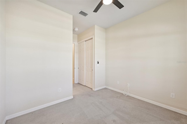 carpeted spare room featuring ceiling fan