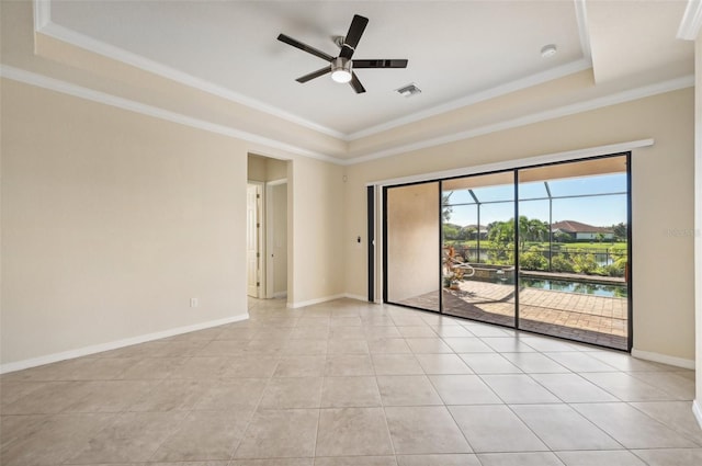 tiled spare room featuring ornamental molding, ceiling fan, and a tray ceiling