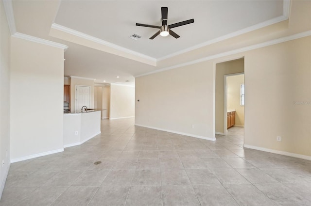 unfurnished living room featuring light tile patterned flooring, ornamental molding, ceiling fan, and a tray ceiling