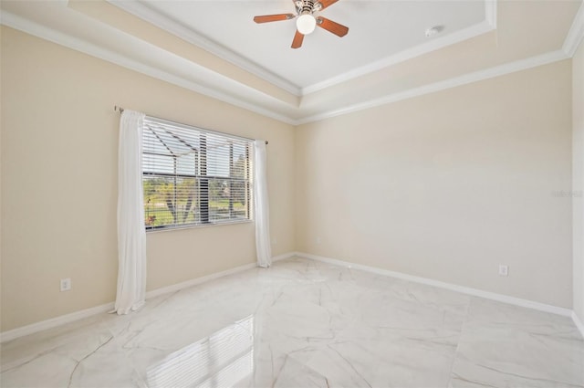 empty room with a raised ceiling, crown molding, and ceiling fan