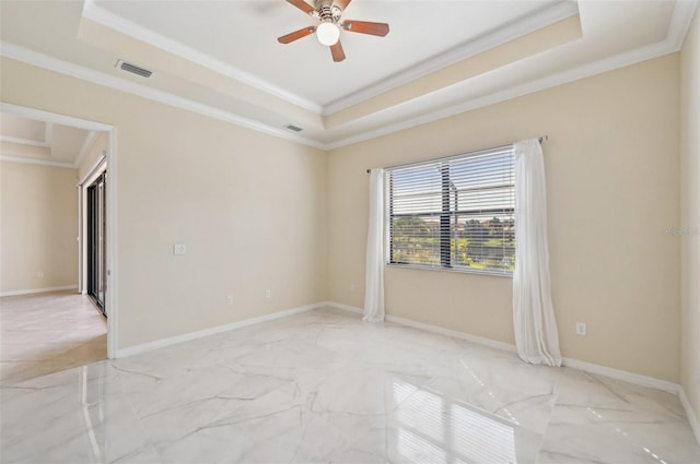 empty room with crown molding, ceiling fan, and a tray ceiling