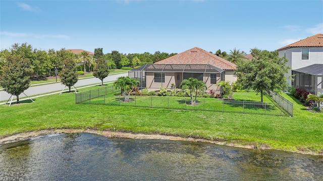 rear view of house featuring a water view, a yard, and glass enclosure