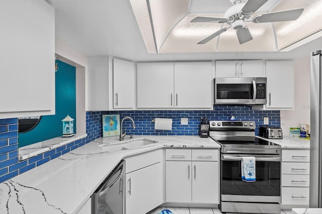 kitchen with white cabinetry, sink, decorative backsplash, ceiling fan, and stainless steel appliances