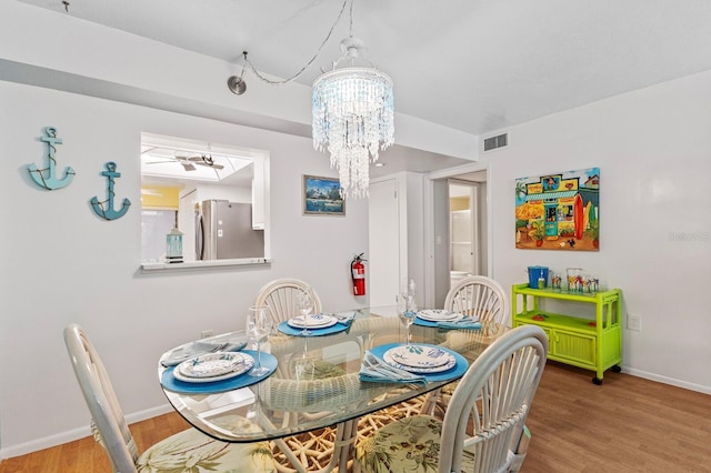 dining space with an inviting chandelier and hardwood / wood-style floors