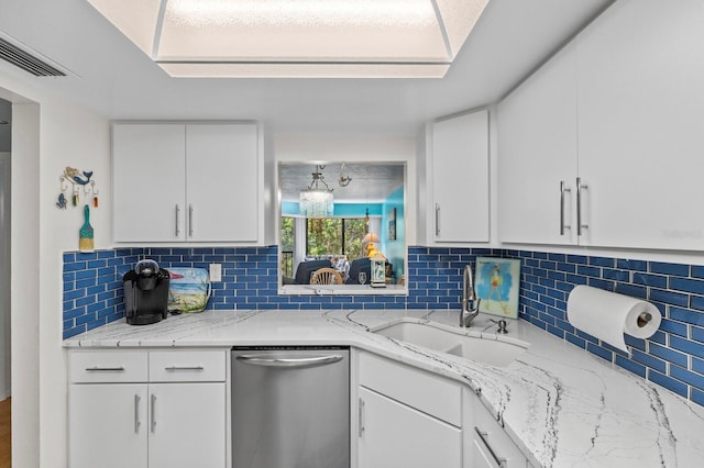 kitchen with sink, stainless steel dishwasher, white cabinets, and backsplash