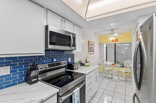 kitchen featuring white cabinetry, light stone counters, decorative backsplash, and appliances with stainless steel finishes