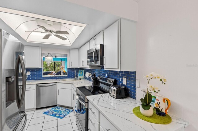 kitchen featuring white cabinetry, appliances with stainless steel finishes, backsplash, and ceiling fan