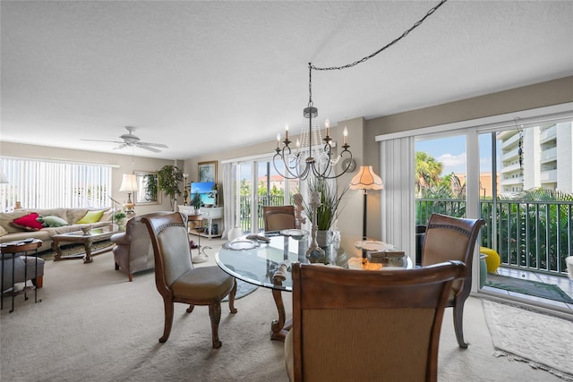 dining space with ceiling fan with notable chandelier and carpet