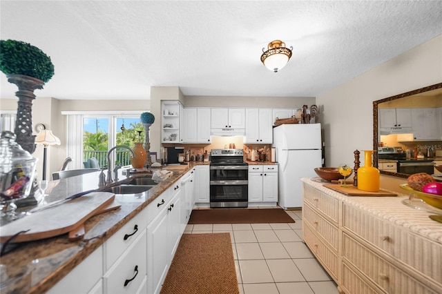 kitchen with light tile patterned flooring, white cabinetry, white refrigerator, and electric stove