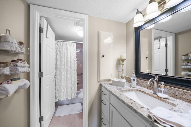 bathroom with vanity, tile patterned floors, a textured ceiling, and toilet