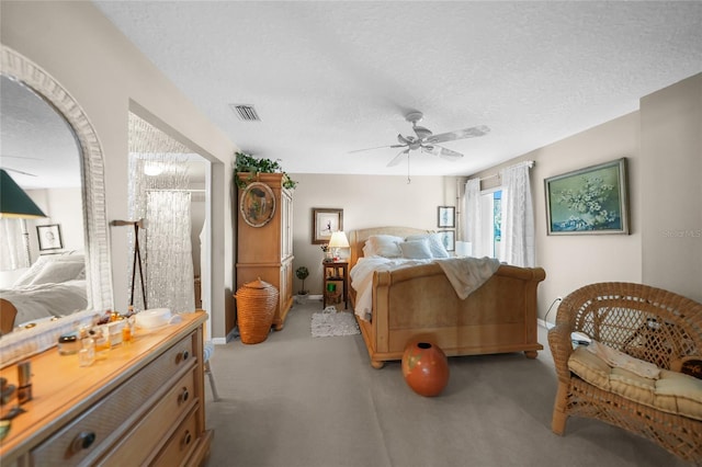 bedroom with a textured ceiling, ceiling fan, and light carpet