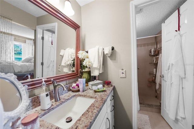 bathroom with vanity, a textured ceiling, and tile patterned flooring