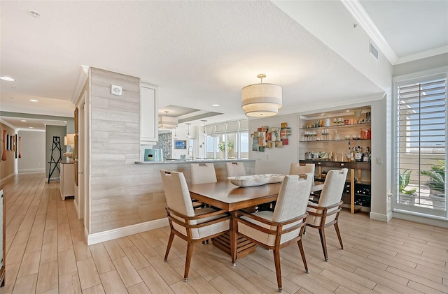 dining space featuring crown molding, wet bar, and a textured ceiling