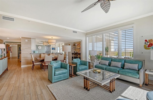 living room featuring ceiling fan, light hardwood / wood-style flooring, and ornamental molding