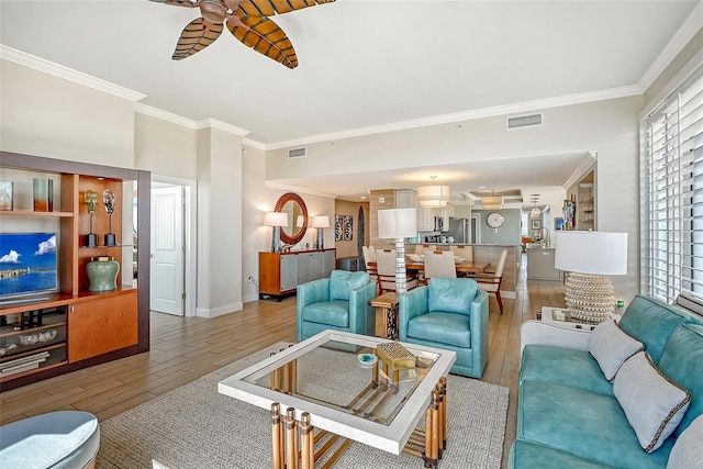 living room featuring ceiling fan, ornamental molding, and hardwood / wood-style floors