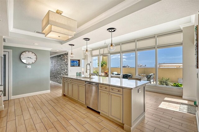 kitchen with sink, ornamental molding, a center island with sink, stainless steel dishwasher, and a raised ceiling