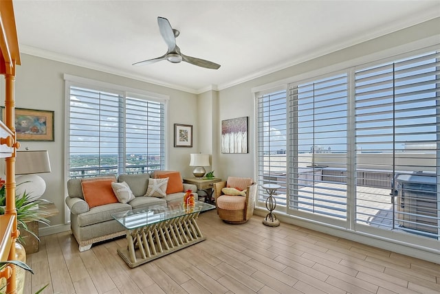 living area with ceiling fan, ornamental molding, and light wood-type flooring