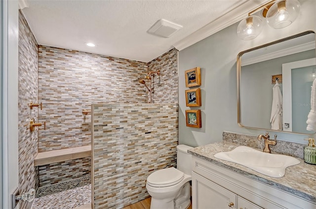 bathroom featuring tiled shower, toilet, crown molding, a textured ceiling, and vanity